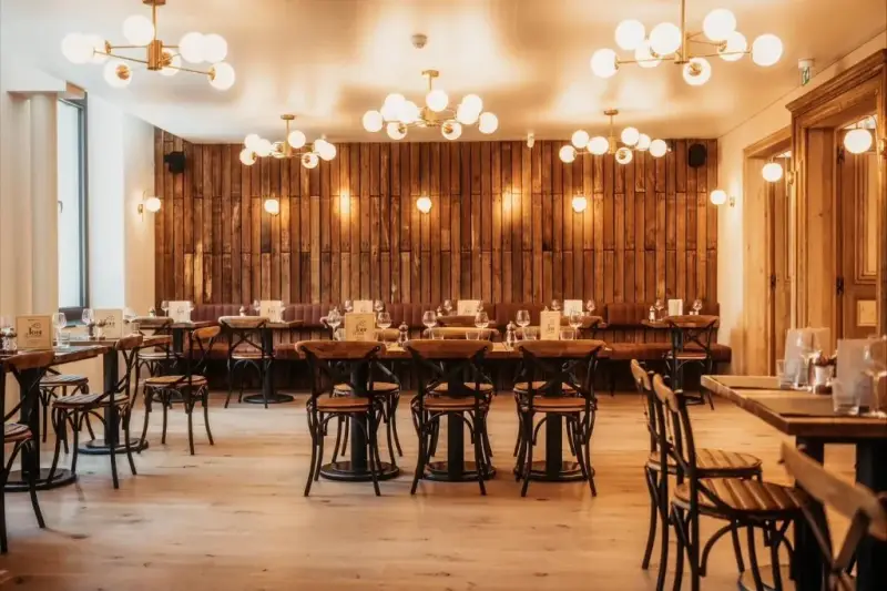 Salle du restaurant La Tour des Légendes à Ath, mur en bois et lustres